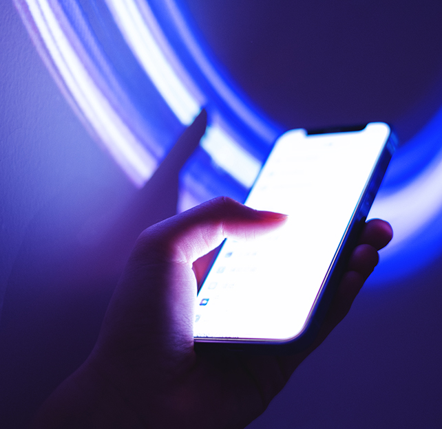 Phone in hand with neon lights surrounding